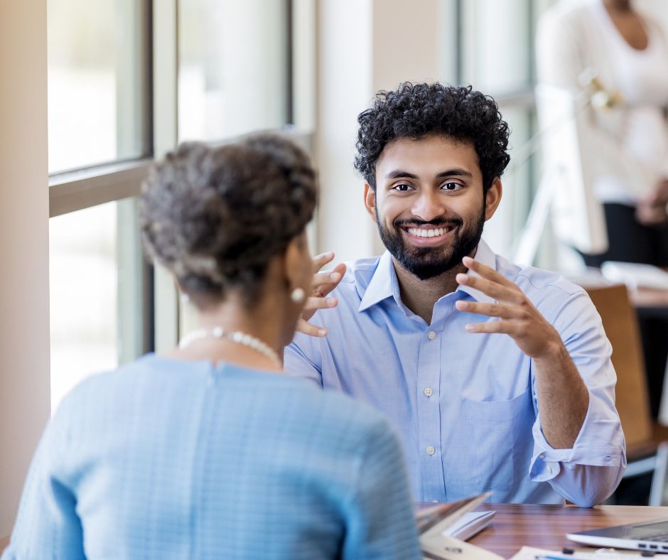 Man and woman sitting at table talking.