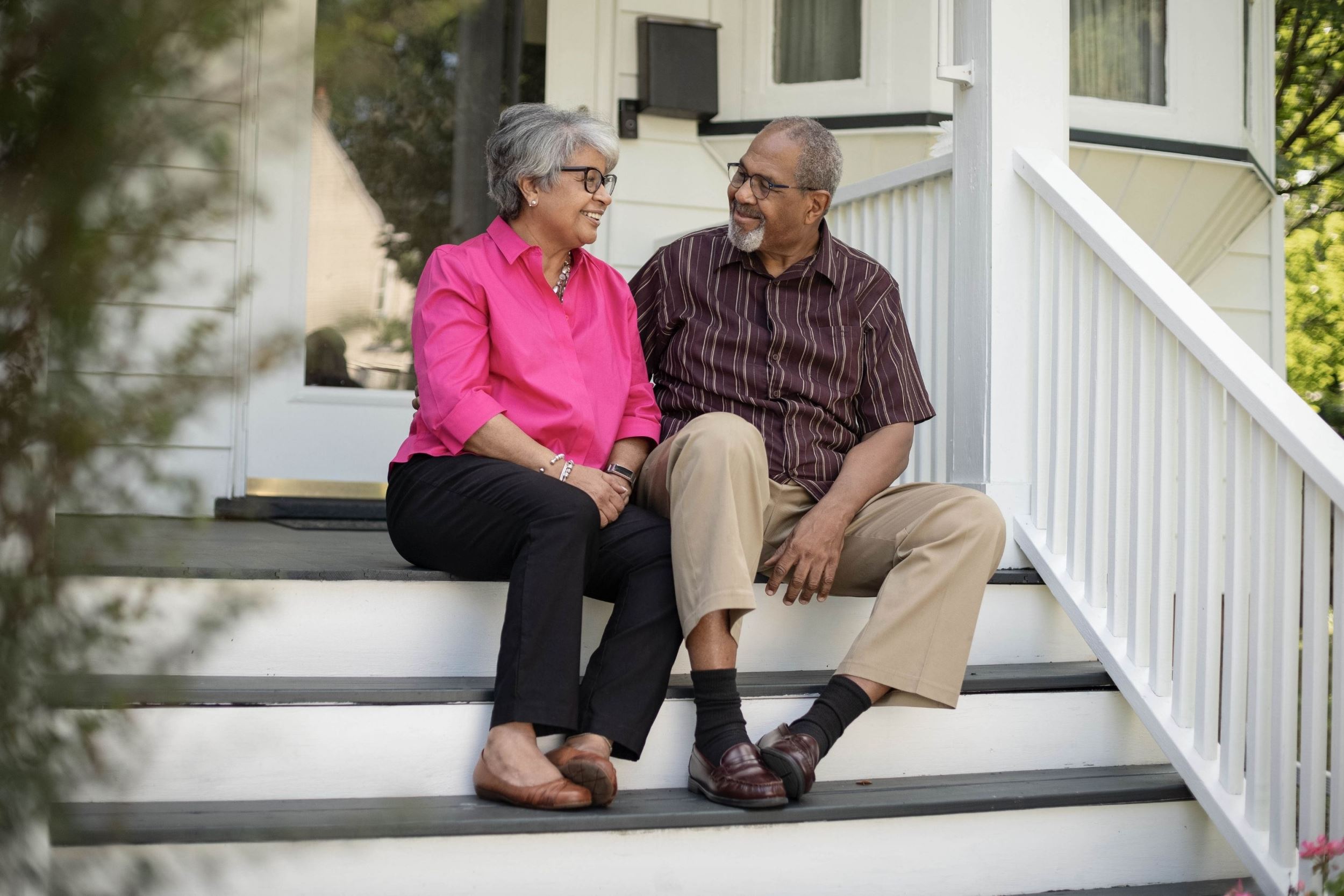 a couple sitting on a front porch step